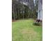 Home's backyard with a spacious lawn, privacy fence, and mature trees at 282 W Thicket Dr, Angier, NC 27501