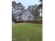 Backyard view of home with a spacious yard, deck, and wooden fence at 282 W Thicket Dr, Angier, NC 27501