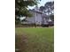Spacious backyard featuring lush green grass, a stone patio, and a two-story home at 282 W Thicket Dr, Angier, NC 27501