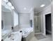 Bathroom with a soaking tub with white tile surround and glass door shower stall at 282 W Thicket Dr, Angier, NC 27501