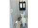 Compact bathroom featuring a toilet, storage cabinet, and neutral tile flooring at 282 W Thicket Dr, Angier, NC 27501