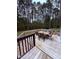 Deck with outdoor table set and chairs overlooking the wooded backyard at 282 W Thicket Dr, Angier, NC 27501