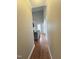 Hallway with hardwood floors leading to the living area with high ceilings and a comfortable grey sofa at 282 W Thicket Dr, Angier, NC 27501