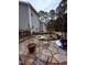 Outdoor patio with stone flooring, dining area, and view of the two-story home and wooded backyard at 282 W Thicket Dr, Angier, NC 27501