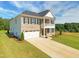 Inviting two-story home featuring a brick facade, a two-car garage and a second-story porch at 3017 Dog Rose Dr # 169, Durham, NC 27703