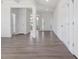 Hallway leading to an entryway featuring light gray wood flooring and white walls at 33 Celtic Ln, Lillington, NC 27546
