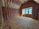 Unfinished bedroom with angled ceiling, pink insulation, and large windows at 3324 Founding Place, Raleigh, NC 27612