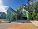 New home in construction phase with green weather resistant barrier, black windows, and a bright blue sky at 3324 Founding Place, Raleigh, NC 27612