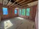 Large unfinished living room with pink insulation and plentiful natural light from multiple windows at 3324 Founding Place, Raleigh, NC 27612