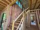 New wooden staircase construction with pink insulation and large window in a framed home at 3324 Founding Place, Raleigh, NC 27612