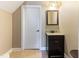 Powder room with tiled floors, a single vanity, and a decorative framed mirror at 3612 Griffice Mill Rd, Raleigh, NC 27610