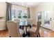 Cozy breakfast nook featuring a glass-top table, upholstered chairs, and views of the lush backyard through large windows at 3612 Griffice Mill Rd, Raleigh, NC 27610