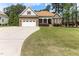 Charming home featuring stone accents, manicured lawn, two-car garage, and well-maintained landscaping at 3612 Griffice Mill Rd, Raleigh, NC 27610