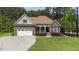 Charming stone and siding home with well-manicured lawn and attached two car garage at 3612 Griffice Mill Rd, Raleigh, NC 27610