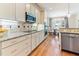 Modern kitchen with stainless steel appliances, granite countertops, tiled backsplash, and hardwood flooring for easy maintenance at 3612 Griffice Mill Rd, Raleigh, NC 27610