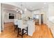 Open kitchen layout with a breakfast bar, white cabinetry, stainless steel appliances, and hardwood flooring throughout at 3612 Griffice Mill Rd, Raleigh, NC 27610