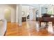 Elegant living room showcasing gleaming wood floors, an archway, and a stunning grand piano at 3612 Griffice Mill Rd, Raleigh, NC 27610