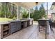Covered outdoor kitchen with stainless steel appliances and bar seating area at 3612 Griffice Mill Rd, Raleigh, NC 27610