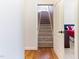 View of carpeted staircase with wooden banister, accessible from a light wooden hallway, and glimpse of the bedroom at 3612 Griffice Mill Rd, Raleigh, NC 27610