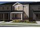 Charming townhome showcases classic design with stone accents, covered entry, and professionally landscaped front yard at 3712 Rosebush Dr, Zebulon, NC 27597
