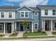 Charming new townhome with blue siding, stone accents, landscaped yard, and inviting front entrance at 3712 Rosebush Dr, Zebulon, NC 27597