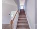 View of the carpeted staircase leading to the second floor with wood banister and spindles at 428 Duncan Creek Rd # 157, Lillington, NC 27546