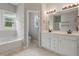 Bathroom with double vanity, tub, and separate toilet area at 4418 Gallatree Ln, Raleigh, NC 27616