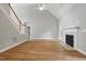 Open living room with hardwood floors, fireplace, ceiling fan, and staircase at 4418 Gallatree Ln, Raleigh, NC 27616