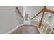 Carpeted stairway with wooden handrails and white balusters, offering a safe and stylish transition between floors at 4418 Gallatree Ln, Raleigh, NC 27616
