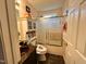 Bathroom features a tub and shower combination with decorative glass door, toilet with shelving, and a vanity with dark countertop at 501 Bellmeade Bay Dr, Durham, NC 27703