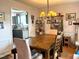Bright dining room open to kitchen with chandelier, large window, and seating for six at 501 Bellmeade Bay Dr, Durham, NC 27703