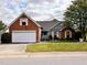 Charming brick home features a two-car garage, well-kept lawn, and complementary grey siding at 501 Bellmeade Bay Dr, Durham, NC 27703