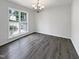 Light-filled bedroom with hardwood floors and a chandelier at 517 Hidden Cellars Dr, Holly Springs, NC 27540