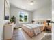 Staged bedroom featuring a sleek modern design with light wood furnishing and bright natural light at 517 Hidden Cellars Dr, Holly Springs, NC 27540