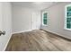 Bright bedroom features wood-look flooring and natural light from two windows at 517 Hidden Cellars Dr, Holly Springs, NC 27540