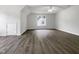 Spacious bonus room features wood-look floors, bright lighting, and a ceiling fan at 517 Hidden Cellars Dr, Holly Springs, NC 27540
