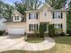 Charming two-story home features a well-manicured lawn, attached garage, and beautiful landscaping at 517 Hidden Cellars Dr, Holly Springs, NC 27540