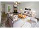 This is a beautifully staged living room with a cozy fireplace, plush seating, and lots of natural light at 517 Hidden Cellars Dr, Holly Springs, NC 27540