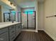 Bathroom featuring a vanity with double sinks and a glass-enclosed shower with tiled walls and a window at 604 Hyperion Aly, Wake Forest, NC 27587