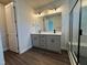 Bright bathroom featuring a double vanity with modern fixtures and a glass-enclosed shower with tiled walls at 604 Hyperion Aly, Wake Forest, NC 27587