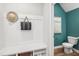 Inviting entryway features a built-in bench with storage and access to a half bathroom with teal accent wall at 604 Hyperion Aly, Wake Forest, NC 27587
