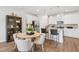 Kitchen and dining area featuring white cabinets, modern appliances and a table with seating at 604 Hyperion Aly, Wake Forest, NC 27587