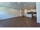Bright, open-concept living space featuring dark wood flooring that flows into the modern kitchen area at 604 Hyperion Aly, Wake Forest, NC 27587