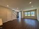 Sunlit open-concept living area with modern wood floors, staircase, and large windows that flood the space with natural light at 604 Hyperion Aly, Wake Forest, NC 27587