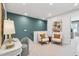 Upstairs sitting room with teal accent wall, neutral carpet, and two cozy chairs in a flex space at 604 Hyperion Aly, Wake Forest, NC 27587