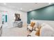 Sitting area with teal accent wall, carpet, desk and chairs provide a cozy and functional flex space at 604 Hyperion Aly, Wake Forest, NC 27587