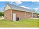Brick house exterior with fenced yard, trash bins and a white door at 6042 Elliott Bridge Rd, Linden, NC 28356