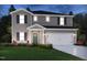 Beautiful two-story home with gray siding, shutters, green door, manicured lawn, and a two-car garage at 640 White Birch Ln, Angier, NC 27501