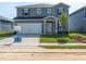 Two-story home features a two-car garage, gray siding, newly planted grass and young tree in front yard at 640 White Birch Ln, Angier, NC 27501