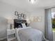 Well-lit bedroom with natural light, featuring neutral tones, a cozy bed, and charming decorative art at 659 White Birch Ln, Angier, NC 27501